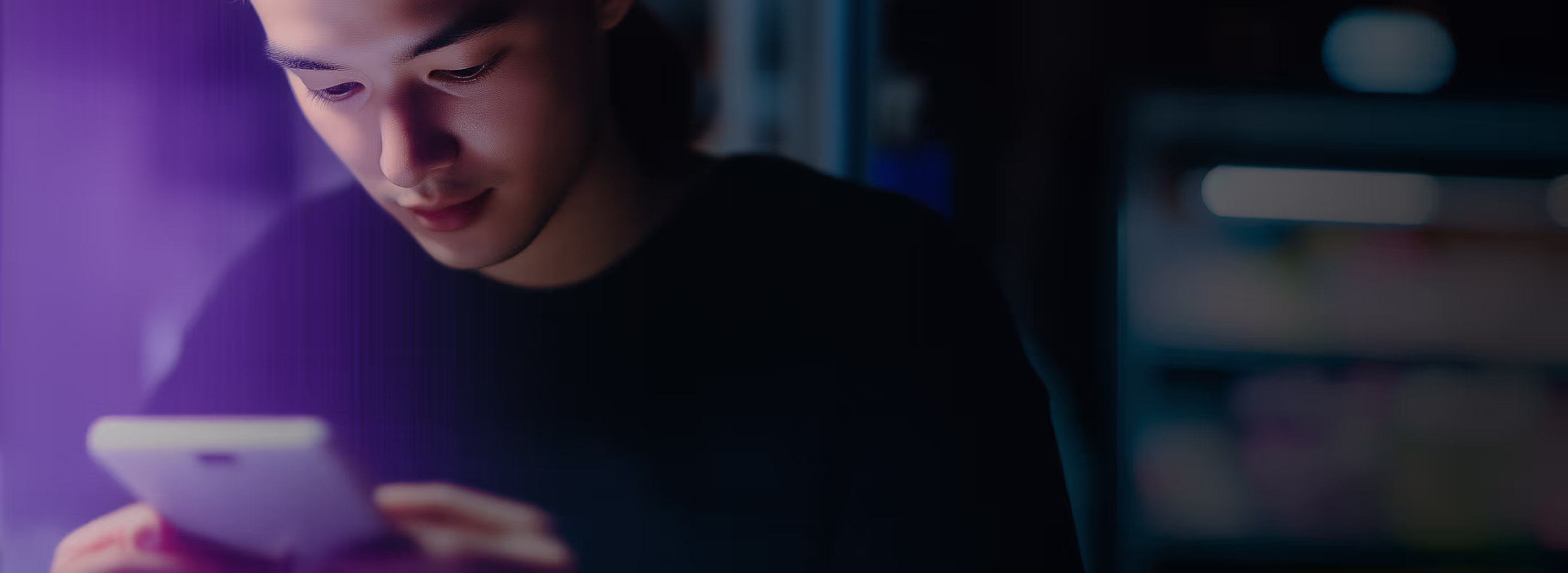 A young individual engrossed in their smartphone, illuminated by a soft purple glow. The image represents online activity, digital identity verification, and the importance of secure interactions. Hindbyte ensures that users can safely engage in the digital world by verifying identities and preventing fraud.